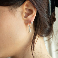 Close-up of an ear wearing a star-shaped earring with a blurred background - seolgold