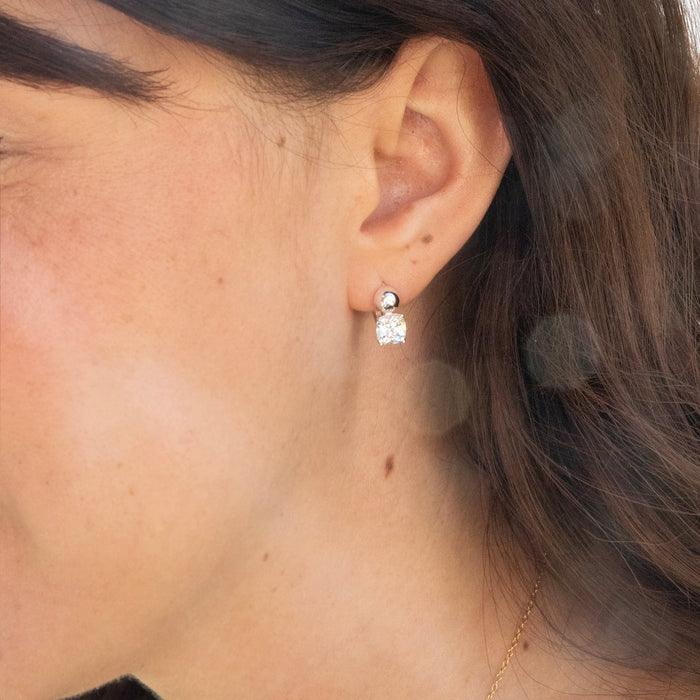 Close-up of an ear wearing a diamond earring with blurred background - seolgold