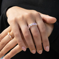 Close-up of a hand wearing multiple rings with gemstones on a black background - seolgold