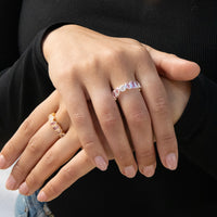 Close-up of hands wearing multiple rings with a black background - seolgold