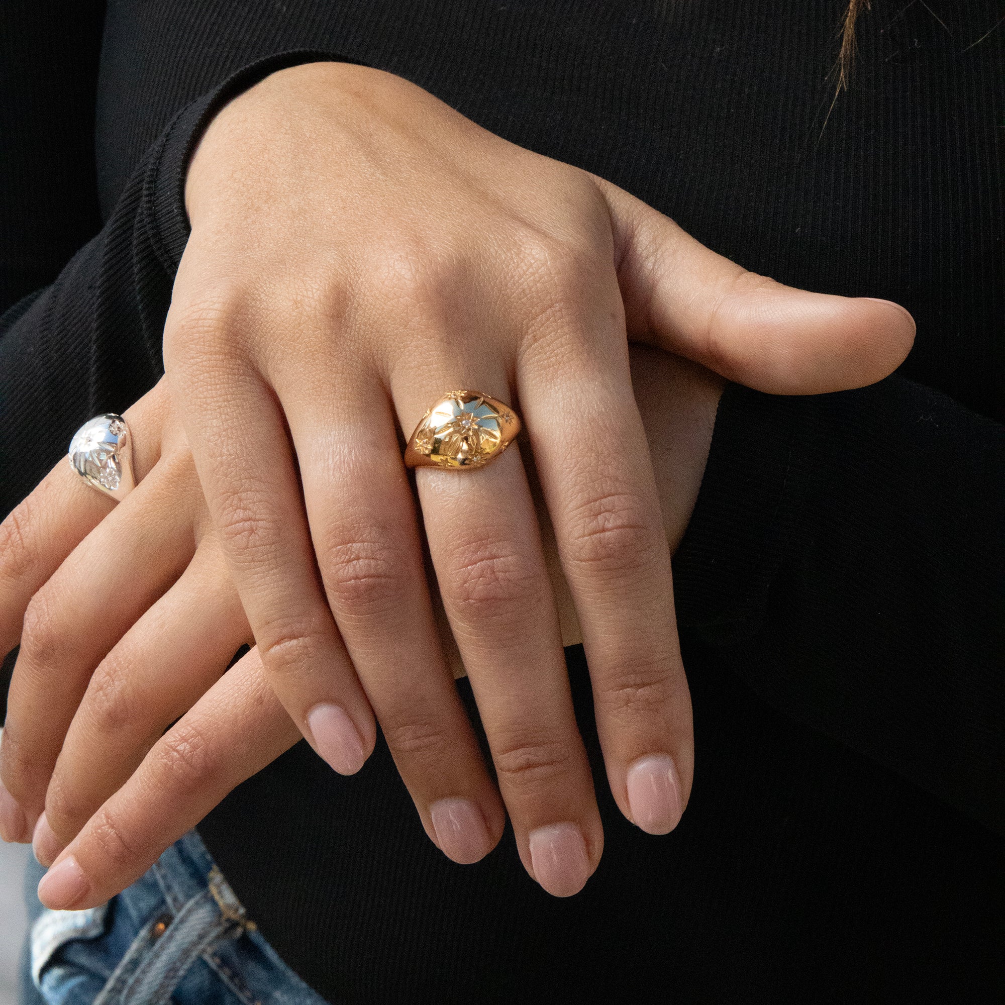 Close-up of hands with gold ring and diamond ring on a black background - seolgold