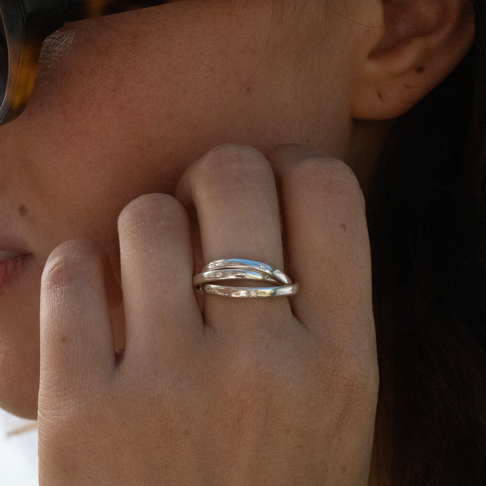 Close-up of a hand wearing a silver ring with a blurred background - seolgold