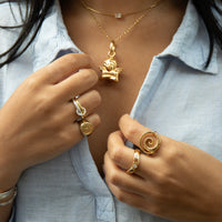 Close-up of a person wearing gold jewelry including a necklace, ring, and bracelet - seolgold