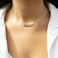 Necklace with 'LUCKY' pendant on a person wearing a white shirt - silver letter slider beads - silver round snake chain - seolgold