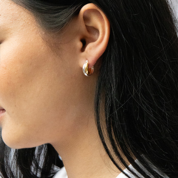 Close-up of a person wearing a gold hoop earring with dark hair - seolgold