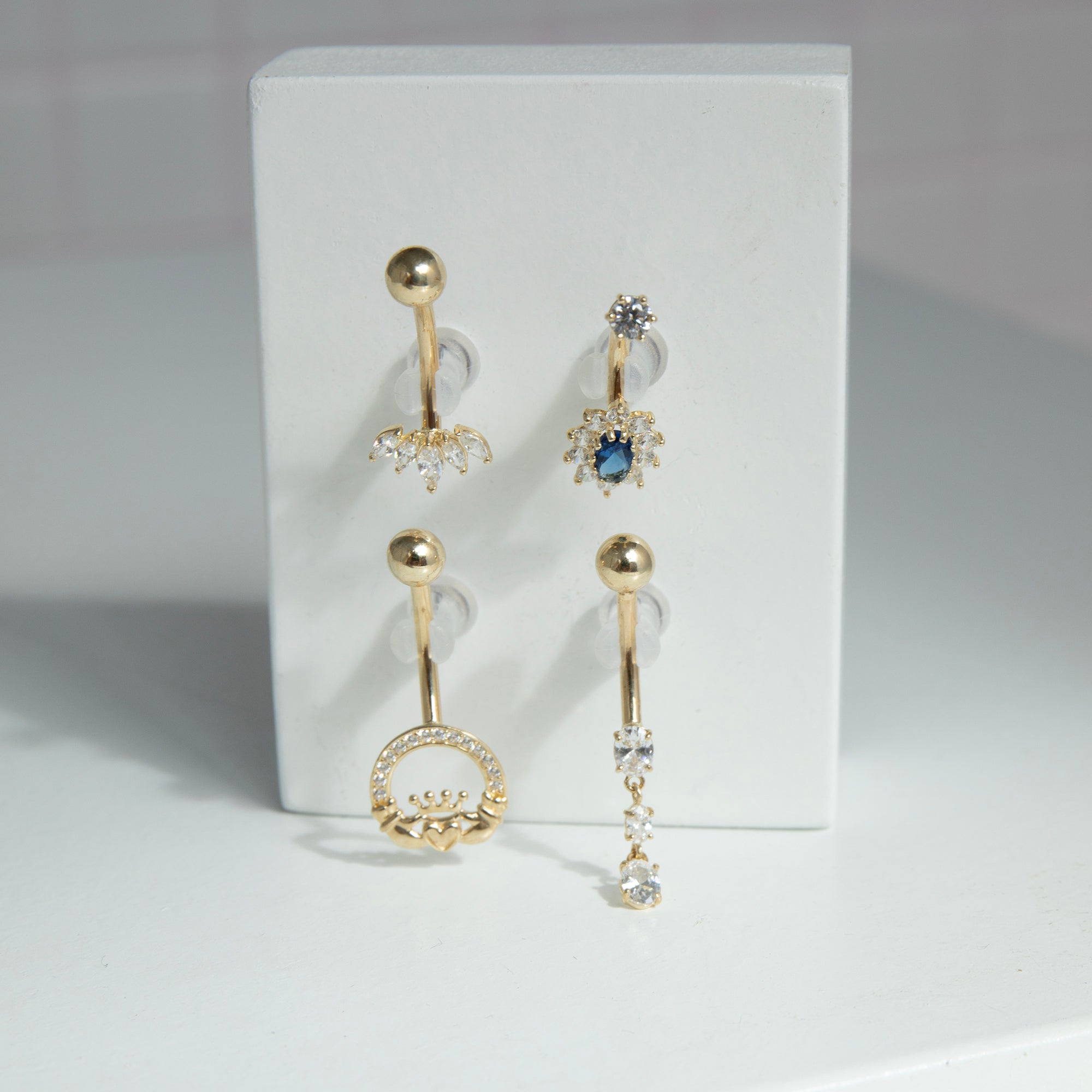 Set of y2k 9ct solid gold belly button rings with gemstones on a white card - seolgold