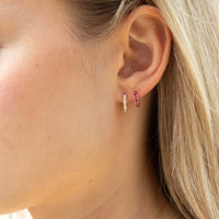 Close-up of an ear wearing two hoop earrings with a blurred background - solid gold hoop earrings - seolgold