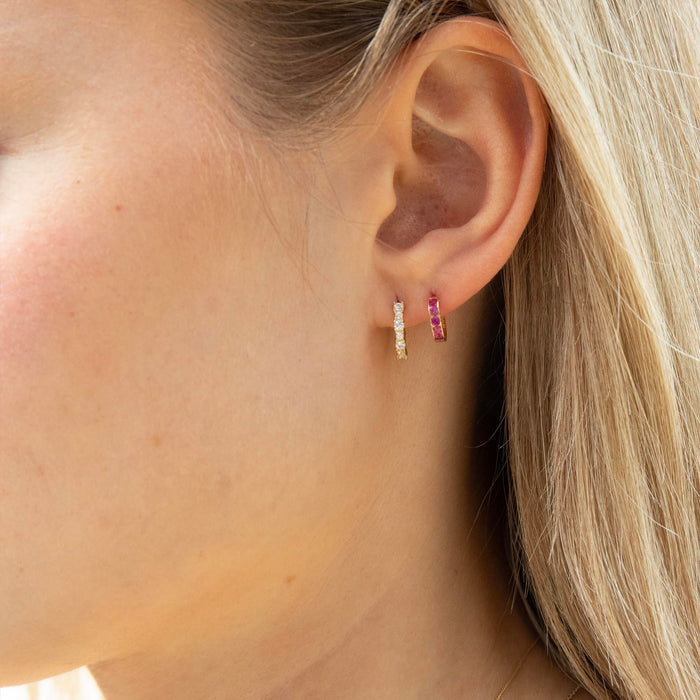 Close-up of an ear wearing two hoop earrings with a blurred background - solid gold hoop earrings - seolgold