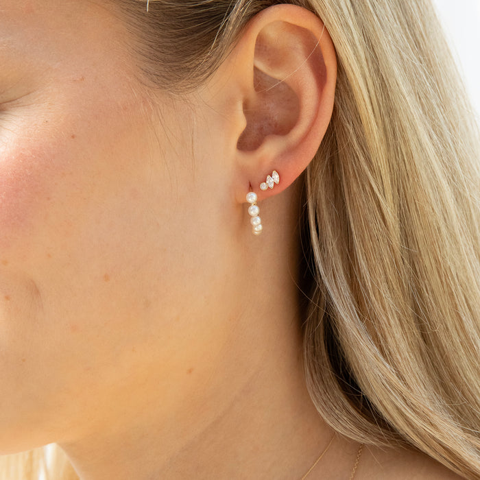 Close-up of a person wearing pearl earrings with blonde hair - seolgold