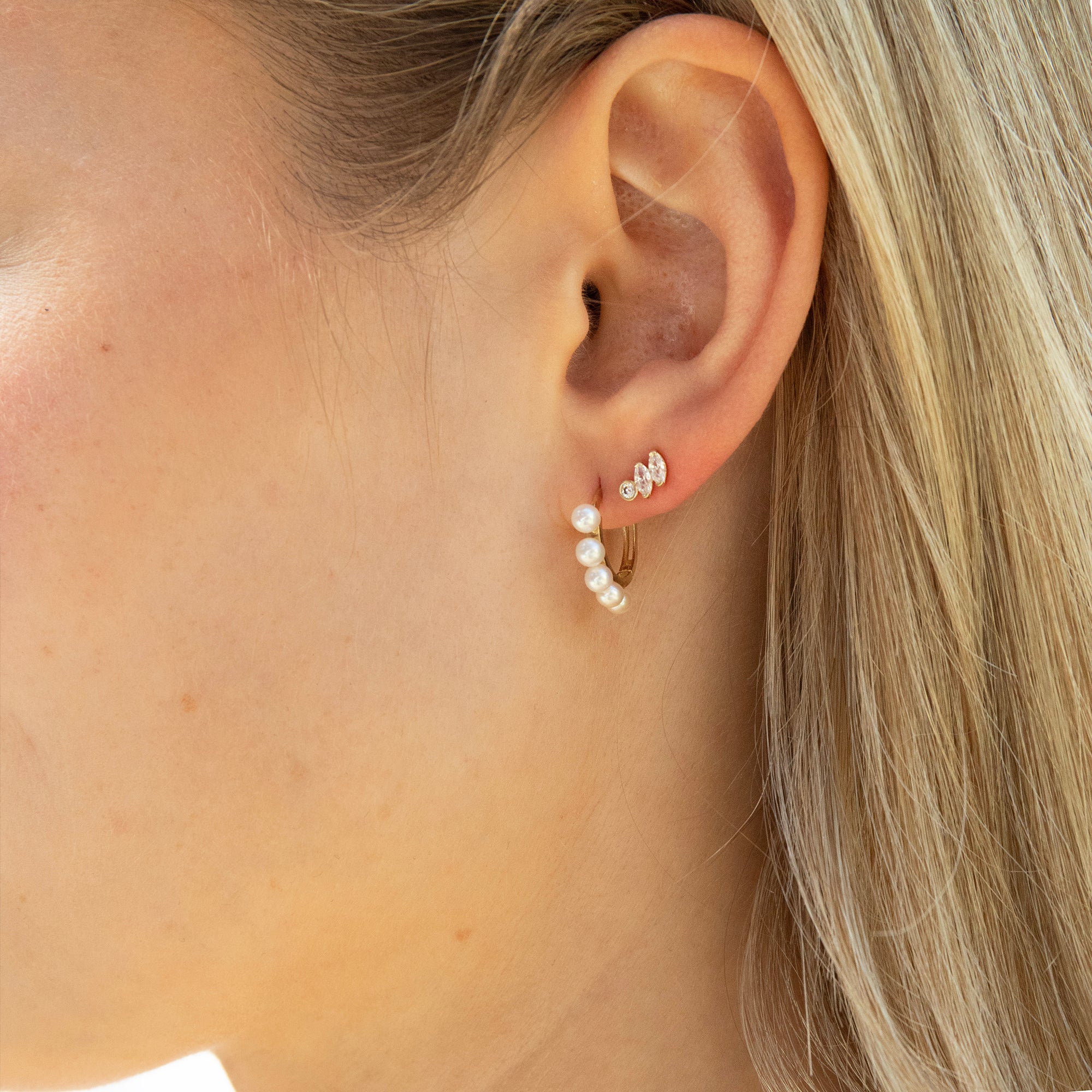 Close-up of an ear wearing pearl and diamond hoop earrings - seolgold