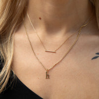 Close-up of a person wearing two gold necklaces with a small pendant - seolgold