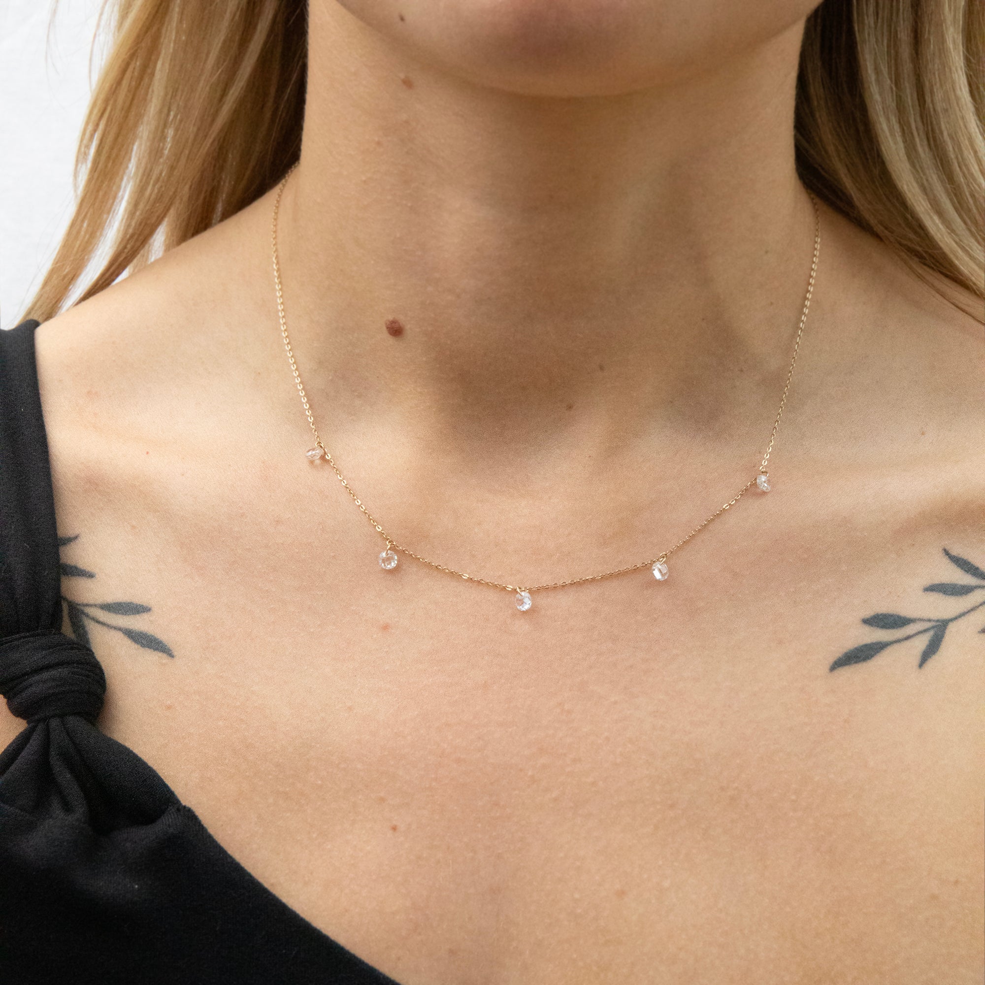 Solid gold necklace with small beads on a person wearing a black top - seolgold