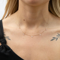 Solid gold necklace with small beads on a person wearing a black top - seolgold