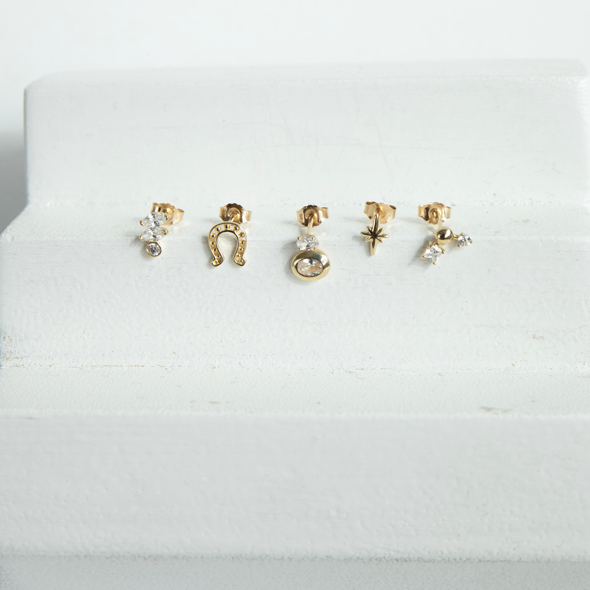 Set of gold and silver earrings on a white cushion - seolgold