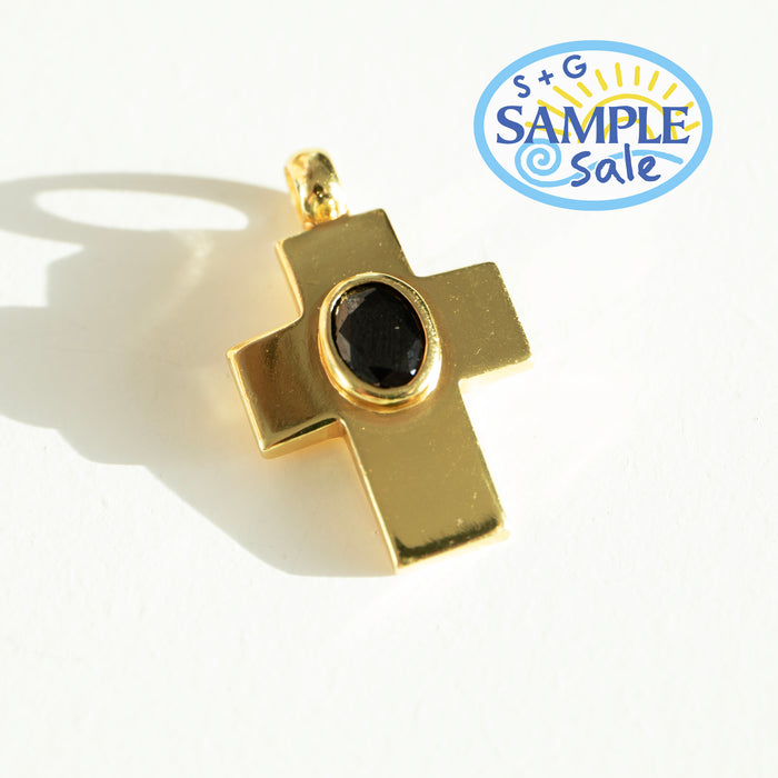Gold cross pendant with a black gemstone on a white background, featuring a 'Sample Sale' label.