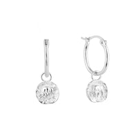 Silver Taurus zodiac charm hoop earrings with round dangling charms on a white background - seolgold