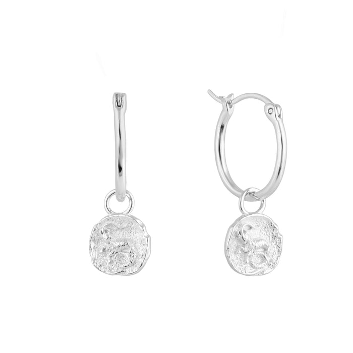 Silver Capricorn zodiac charm hoop earrings with round dangling charms on a white background - seolgold