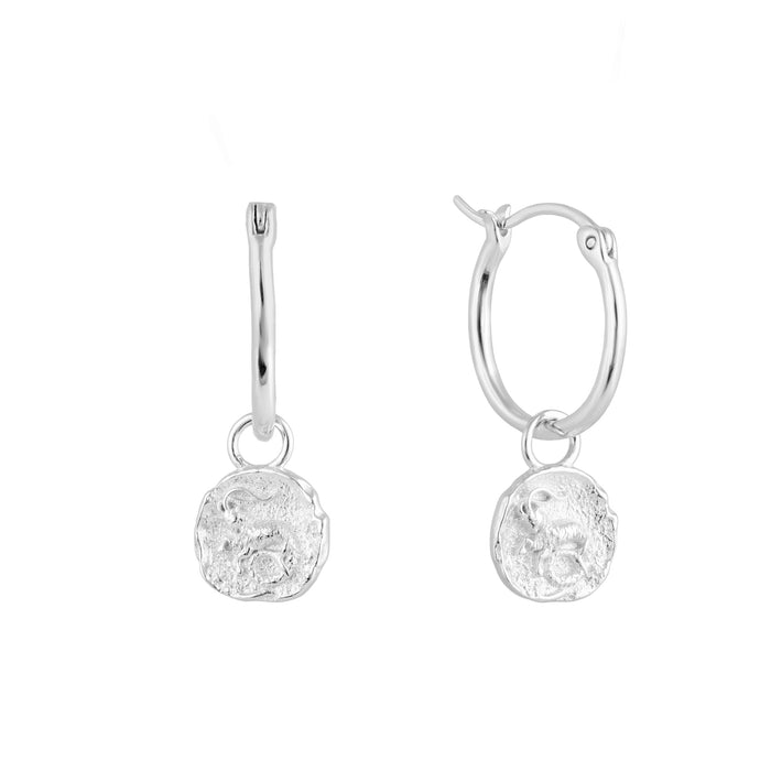 Silver Capricorn zodiac charm hoop earrings with round dangling charms on a white background - seolgold