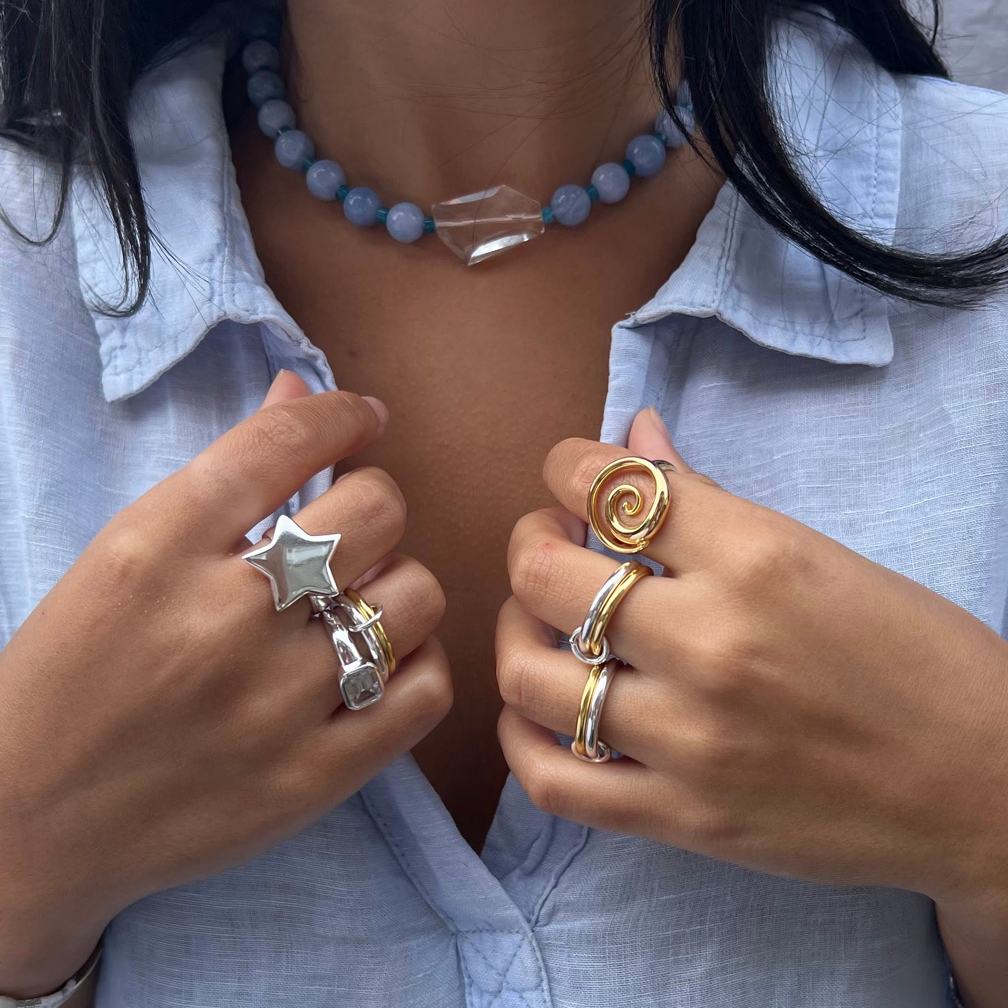 Close-up of a person wearing multiple rings on their fingers, with a focus on jewelry - seolgold