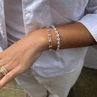 Silver bracelet on a wrist with a blurred background - seolgold