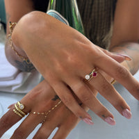 Close-up of a hand with multiple gold rings and a pinky ring on a blurred background - seolgold