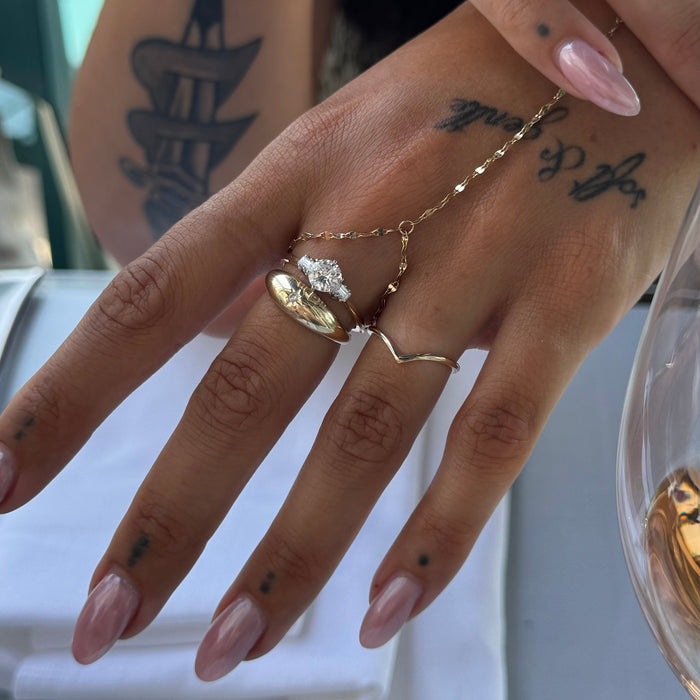 Hand wearing gold rings with a blurred background - seolgold