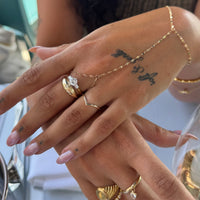 Close-up of hands with gold rings and bracelets, blurred background - seolgold
