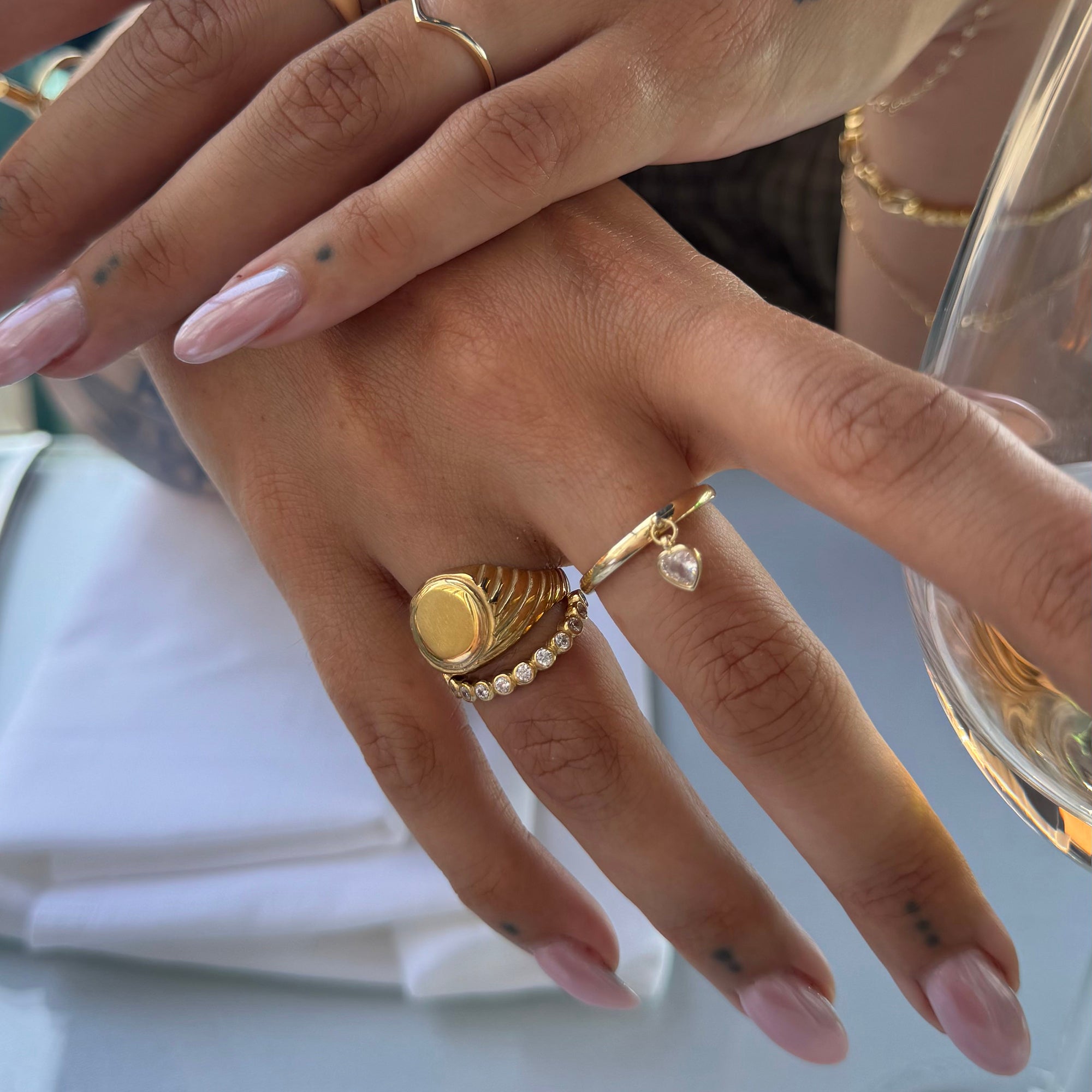 Close-up of a hand wearing gold rings with a blurred background - seolgold