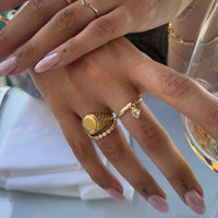 Close-up of a hand wearing gold rings with a blurred background - seolgold