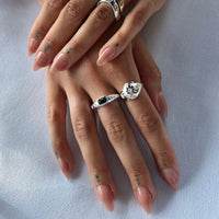 Close-up of hands wearing two rings on a light background - seolgold