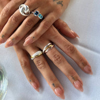 Close-up of hands with multiple rings on a white background - seolgold