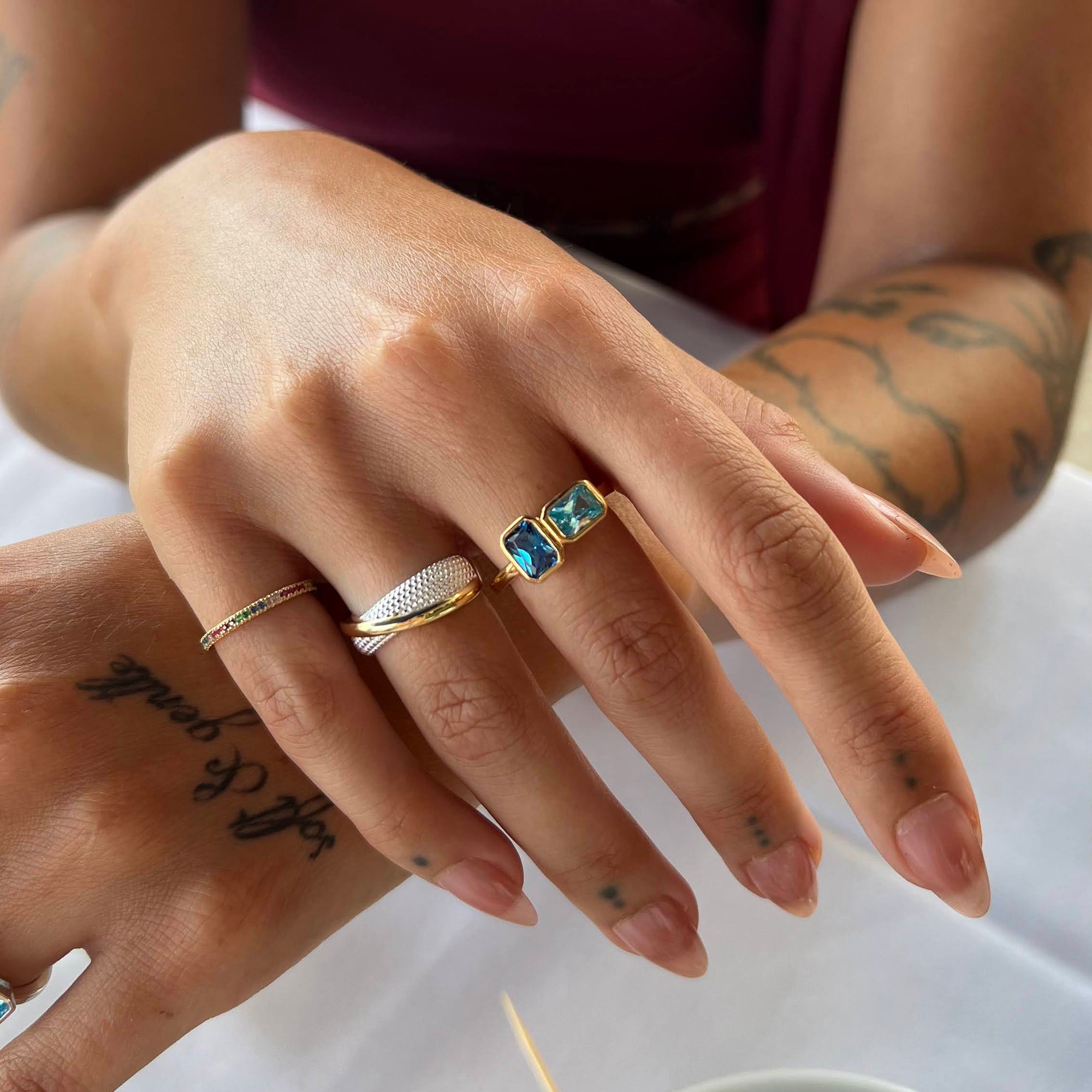 Close-up of a hand wearing multiple rings with a white background - stacking rings - seolgold
