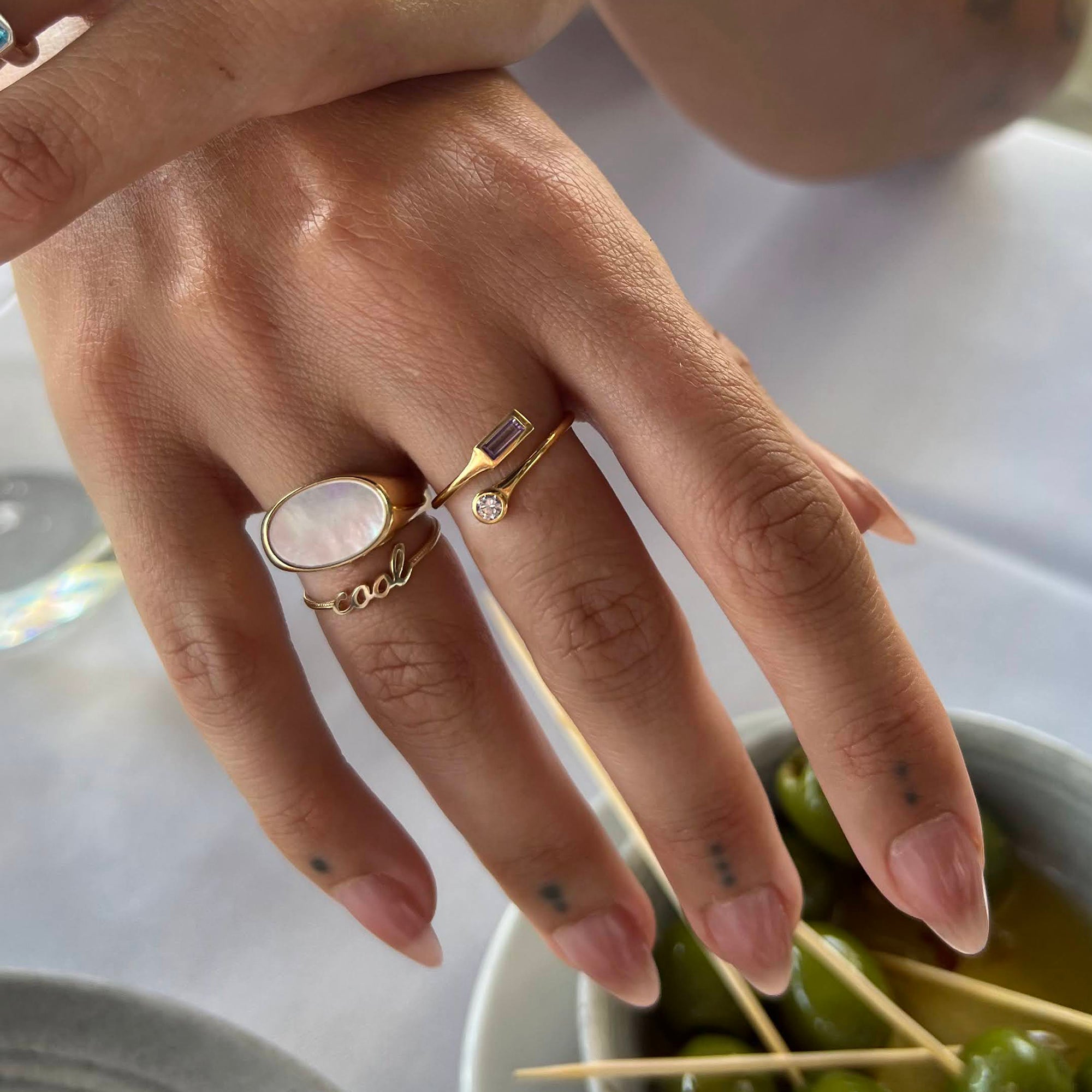 Hand wearing a gold ring with a stone - seolgold