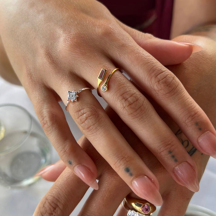 Close-up of a hand wearing multiple rings with a blurred background - seolgold