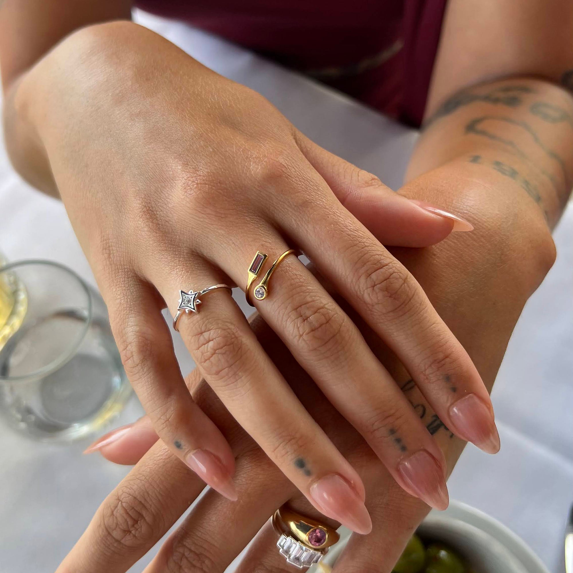 Close-up of hands with multiple rings on a blurred background - silver star ring - seolgold