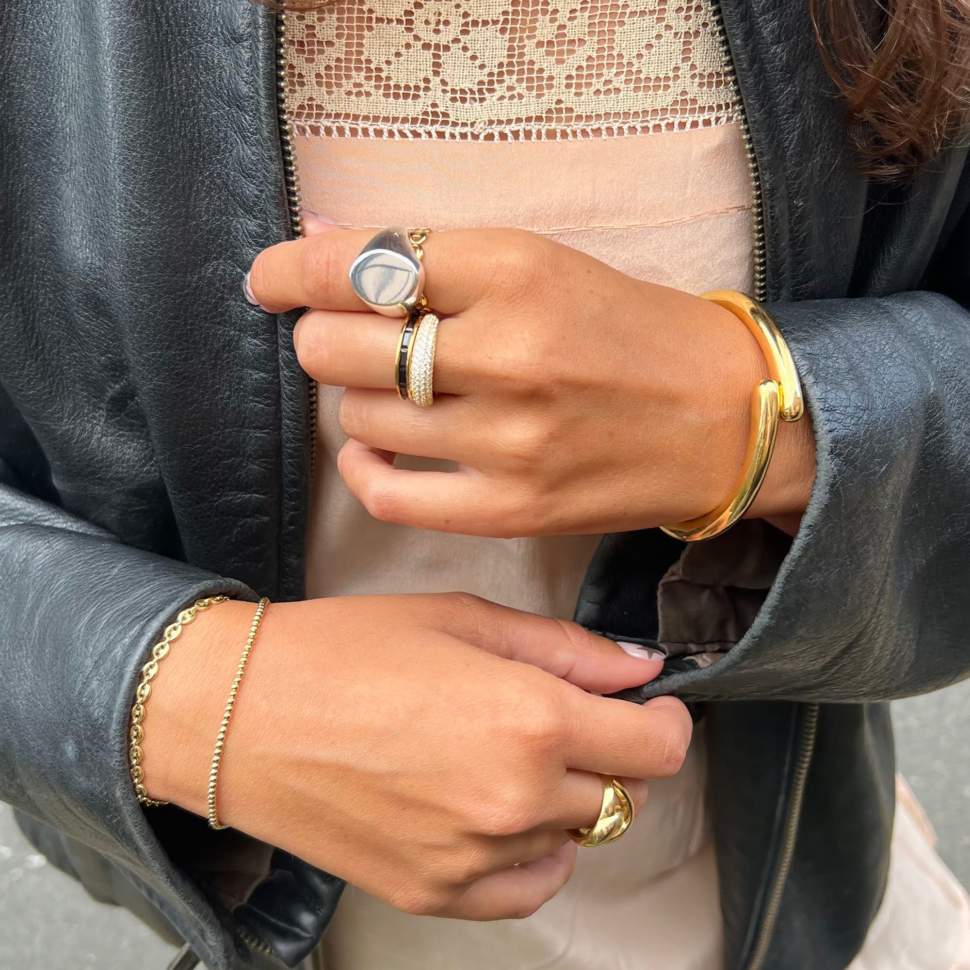 Close-up of hands with gold jewelry on a neutral background - seolgold