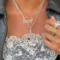 Person wearing a silver necklace with heart pendant and lace detail, holding a phone - seolgold