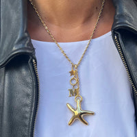 Gold necklace with a starfish pendant worn by a person in a black leather jacket and white shirt - seolgold