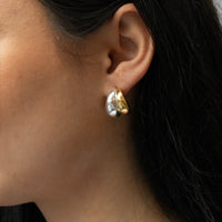 Close-up of an earring worn by a person with dark hair - seolgold