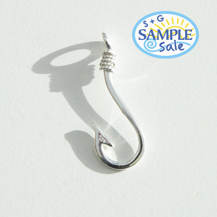 Silver fishing hook on a white background, featuring S+G Sample Sale logo - seolgold