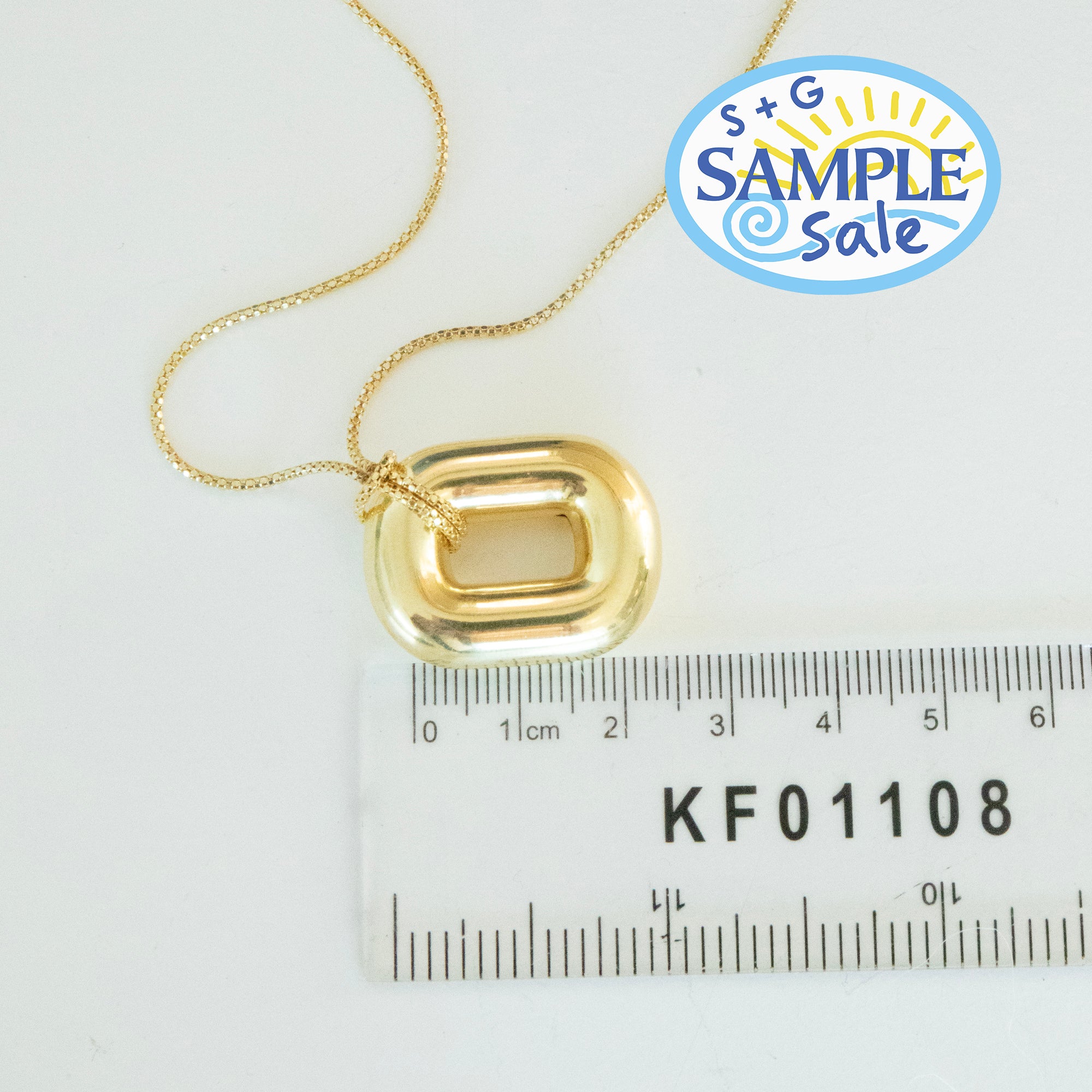 Gold necklace with a pendant on a white background with a ruler for scale - seolgold