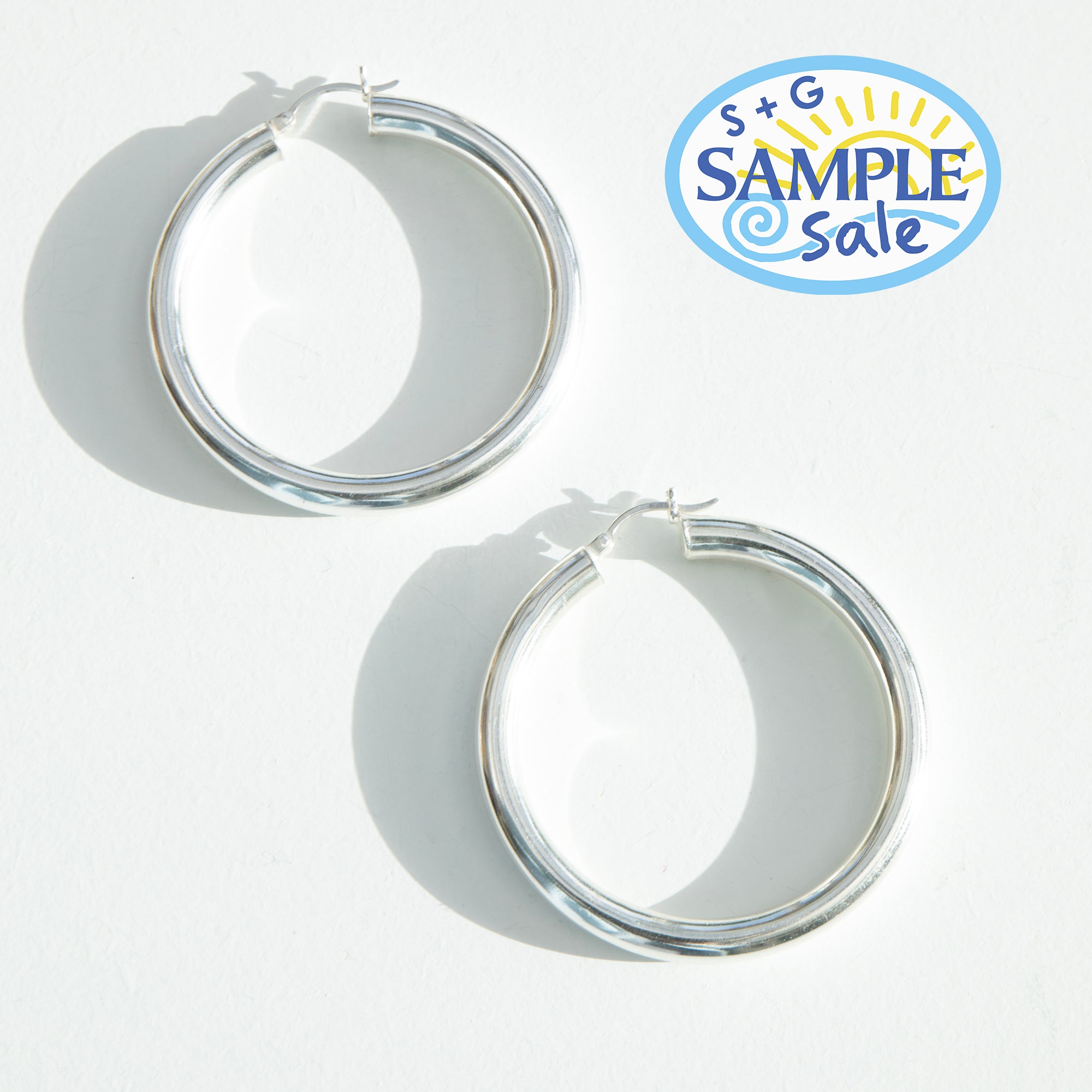 Silver hoop earrings on a white background with 'S+G Sample Sale' logo - seolgold