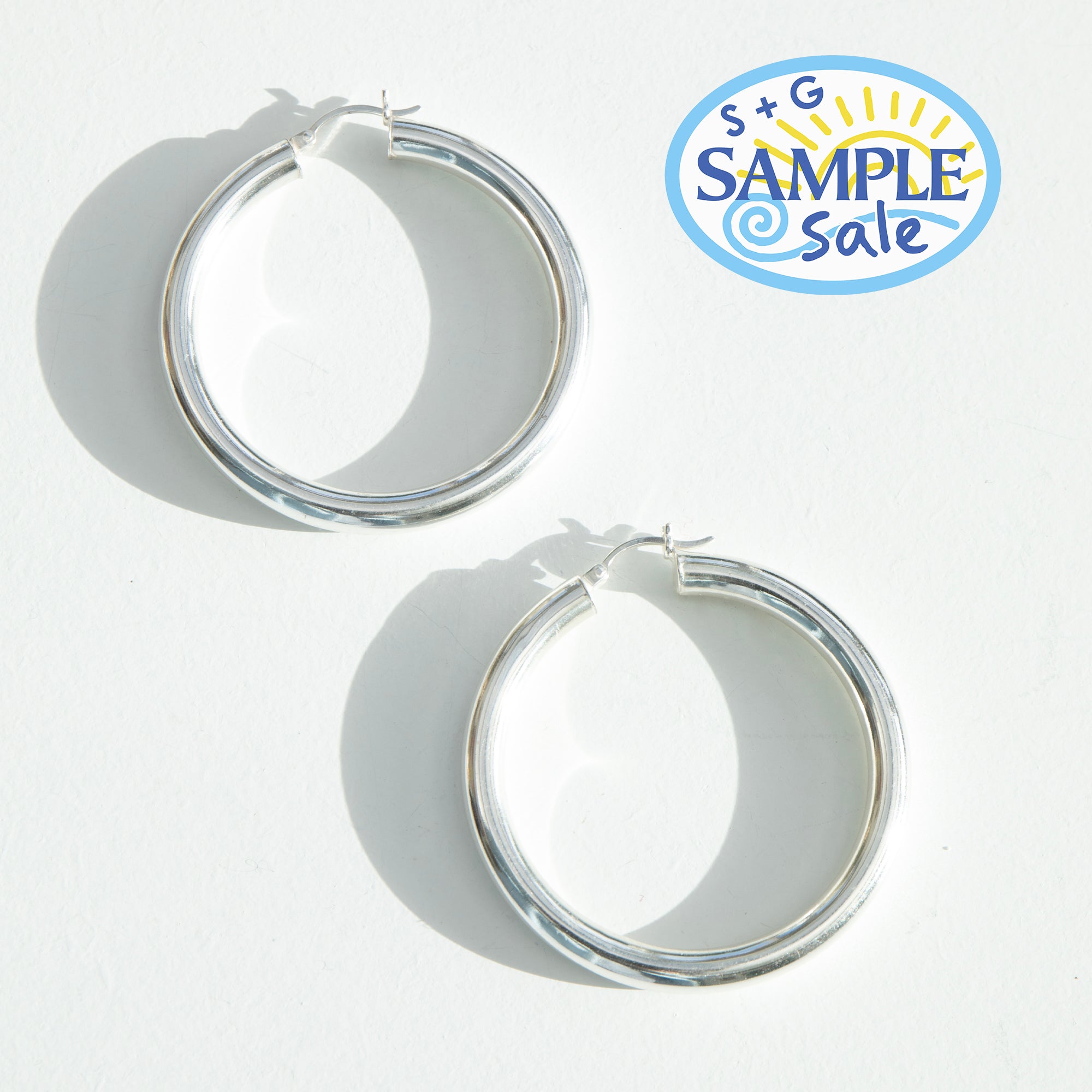 Silver hoop earrings on a white background with 'S+G Sample Sale' logo - seolgold
