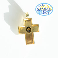 Gold cross pendant with a central gemstone on a white background, featuring a 'Sample Sale' label.