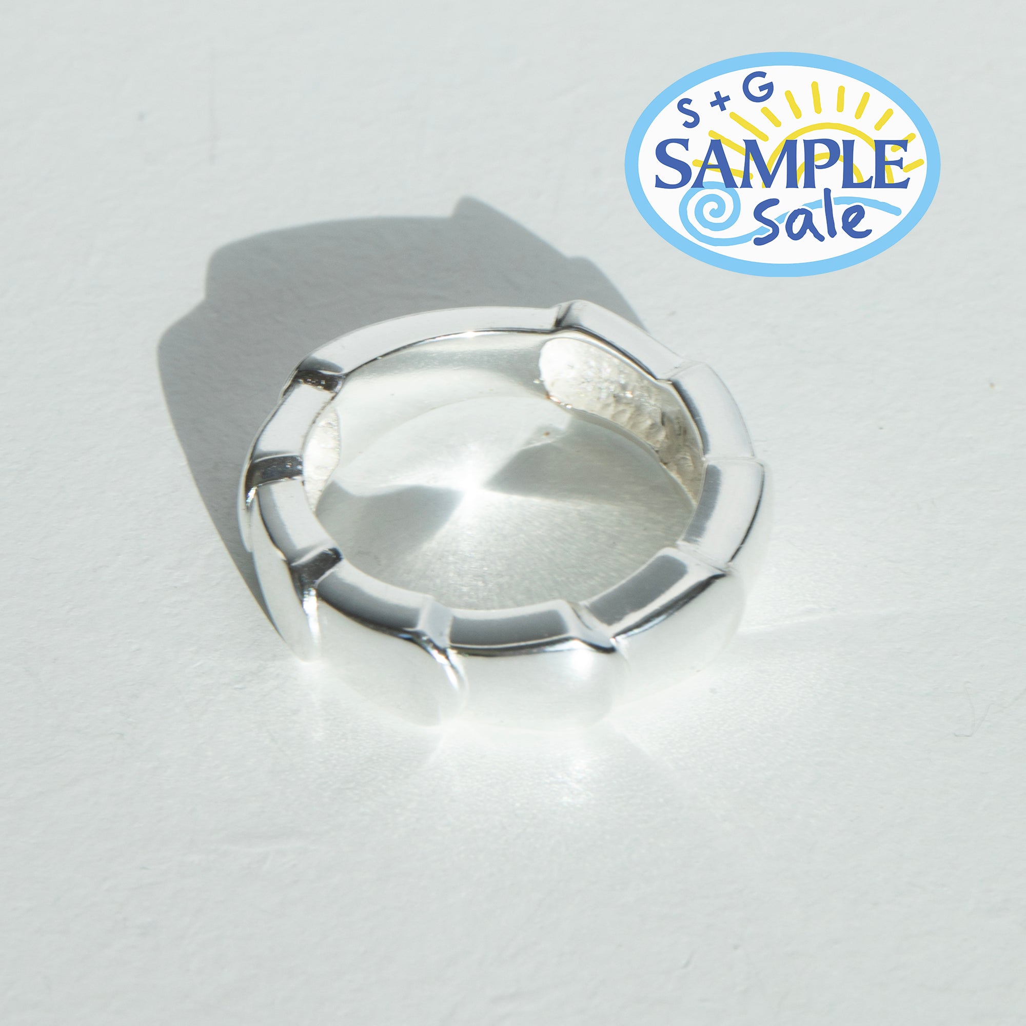Silver ring on a light gray background, featuring S+G Sample Sale logo.