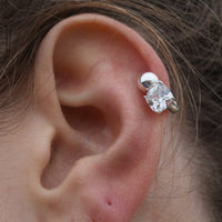 Close-up of an ear wearing a diamond earring with hair partially covering the frame - seolgold