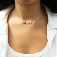 Necklace with 'LUCKY' pendant on a person wearing a white top - seolgold