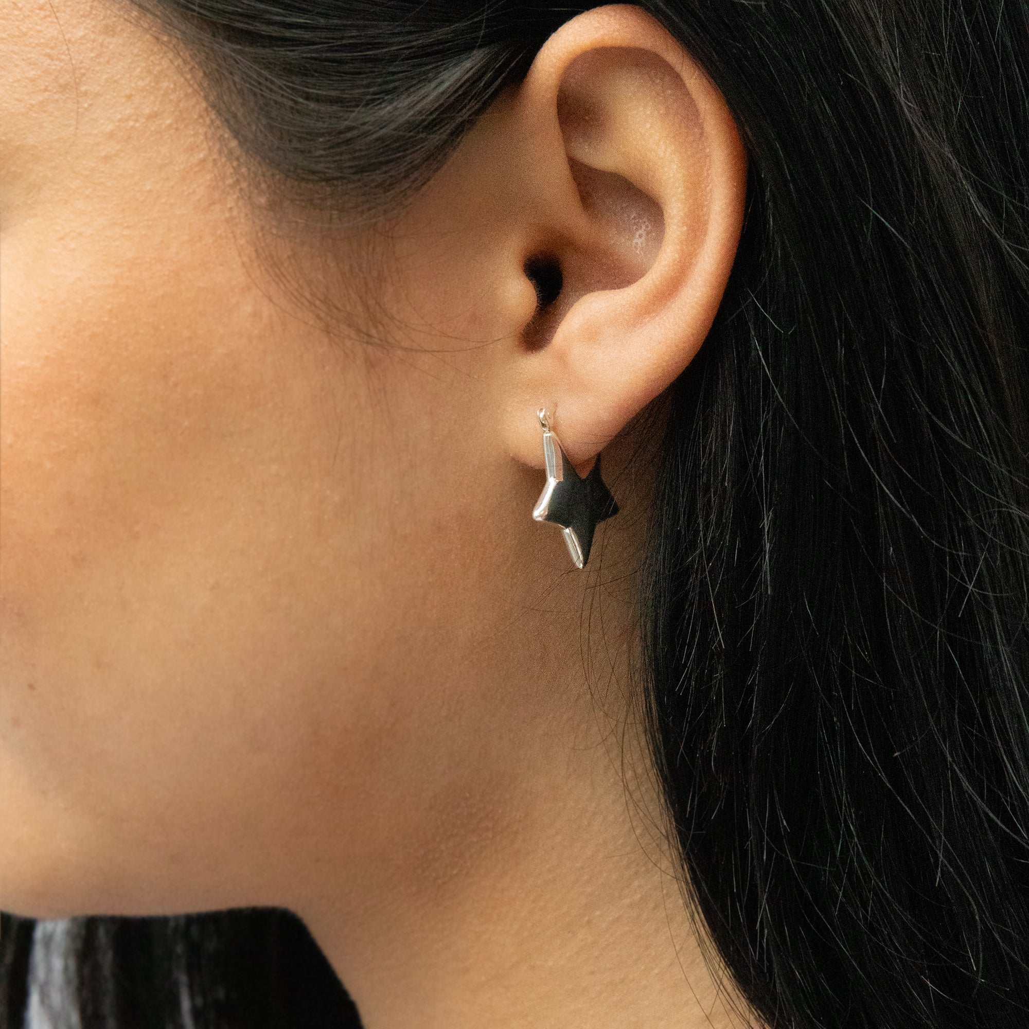 Close-up of an ear wearing a star-shaped earring - Seol Gold