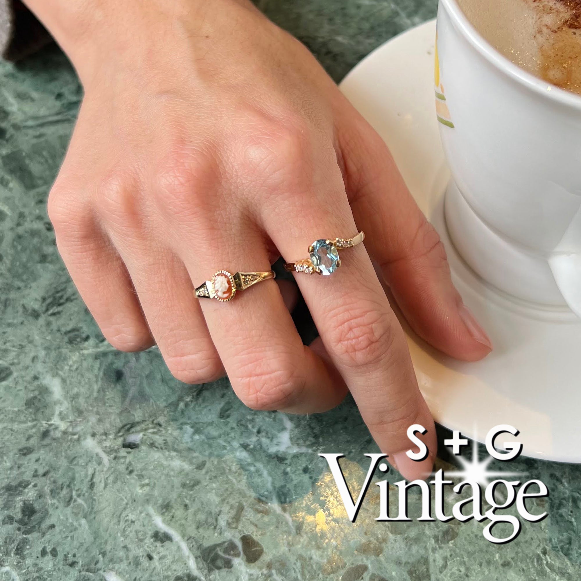 Gold ring with a blue gemstone and diamonds worn on a hand, featuring 'S + G Vintage' branding - seolgold