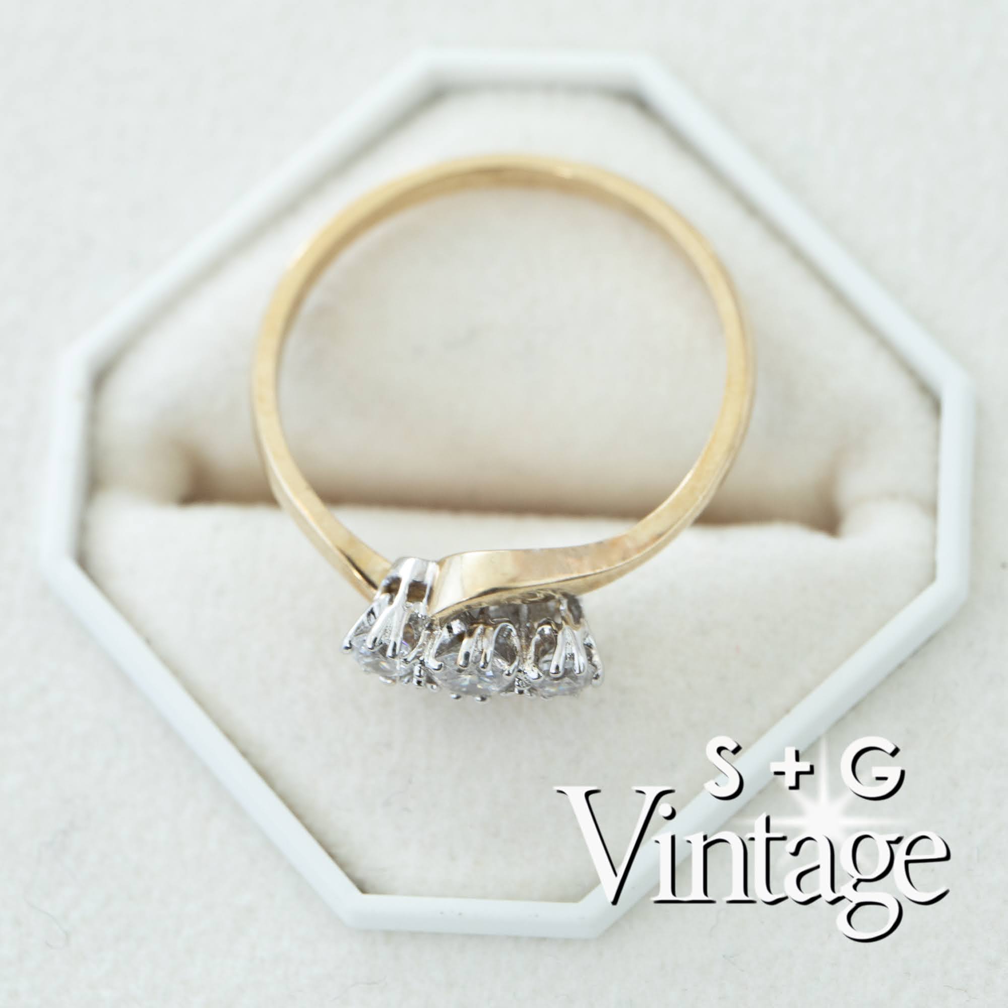 Gold ring with three diamonds on a white hexagonal stand, branded 'S + G Vintage' - seolgold